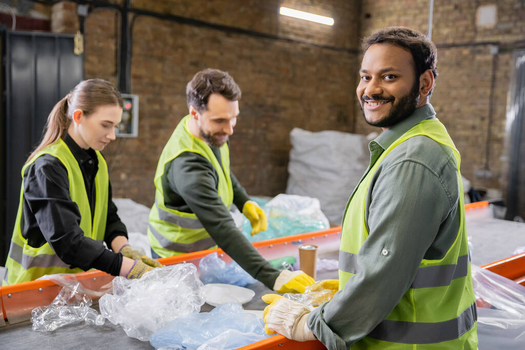 Joyful workers in protective vest gloves